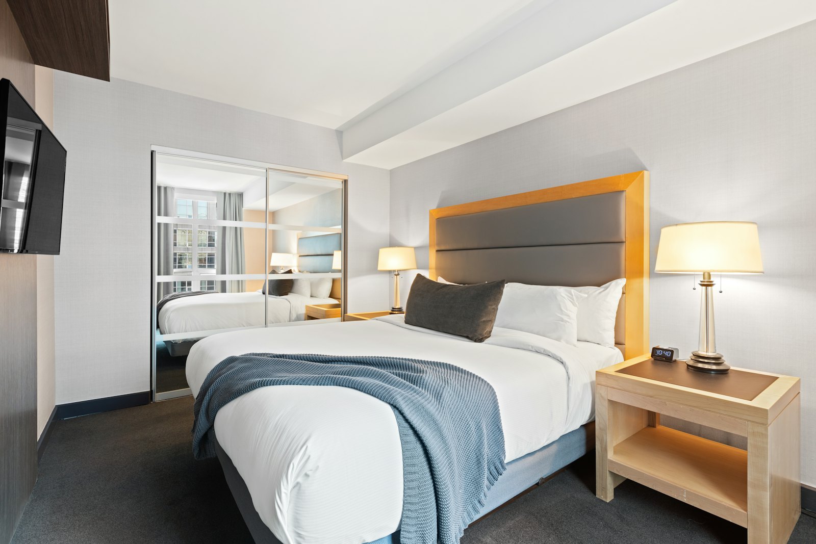 A hotel-style BnB bedroom with a padded headboard and crisp linens